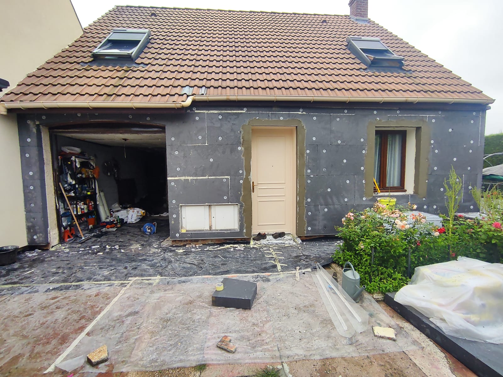 Maison avec garage et fenêtres de toit — pendant l’isolation extérieure
